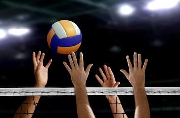 Hands reaching for volleyball at net