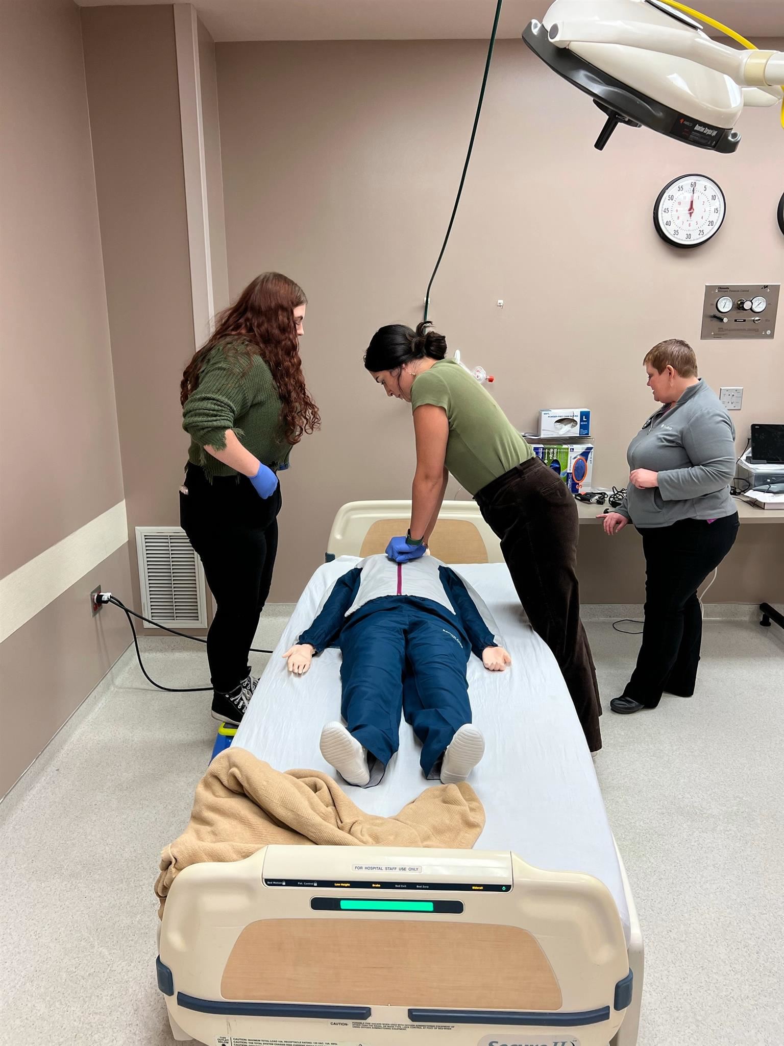 A student performs CPR on a dummy in the Sacred Heart simulation lab.