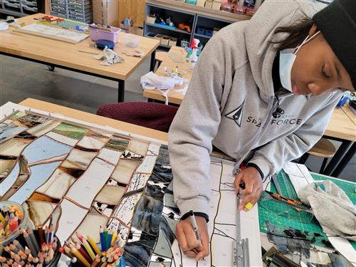 First place high school award winner Najahna Smith, grade 12, On Track Academy, works on a stained glass piece.           