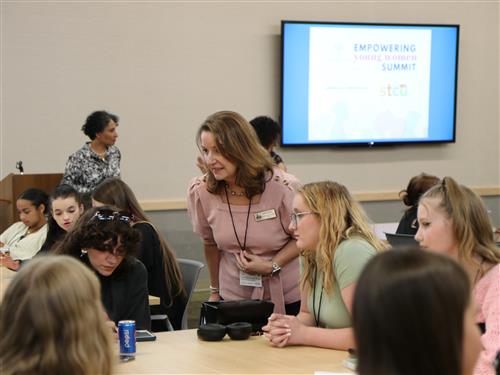 A woman speaks with students. 