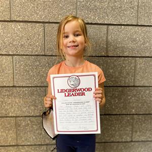 Kindergarten Lidgerwood Leader smiles for camera holding her certificate 