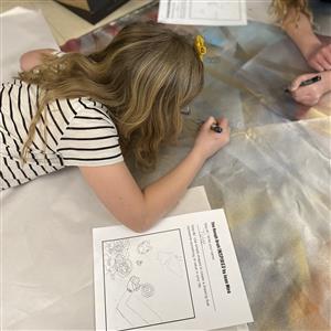 Student drawing cartoon bees on canvas 