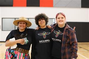 Lacey Bacon-Abrahamson smiles for a photo with two eigtht grade students wearing Sacajawea Middle School t-shirts.