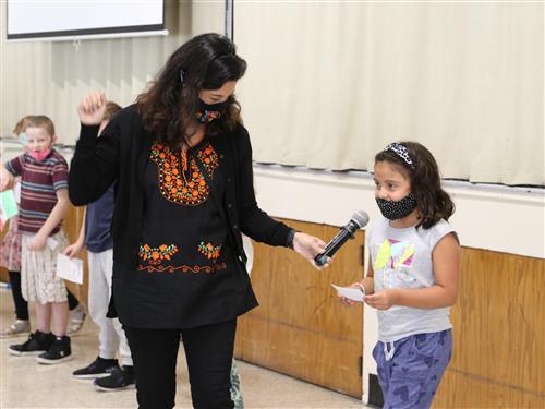 Nancy Gonzales holding microphone for student 