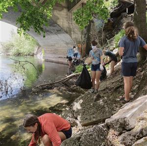 Students cleaning up a riverbank. 