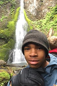 student with waterfall in background